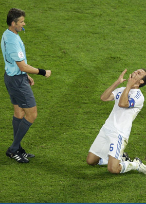 Match referee Roberto Rosetti of Italy (L) watches as Greece's Angelos Basinas reacts after being fouled during their Group D Euro 2008 soccer match against Russia at the Wals-Siezenheim stadium in Salzburg, June 14, 2008. 