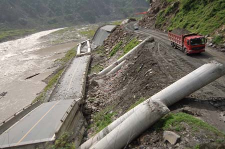 An engineering vehicle passes the temporary line of the No. 213 national highway connecting Dujiangyan City and Wenchuan County in southwest China's Sichuan Province, June 17, 2008. Some 43.3 kilometers of the national and provincial highways still remain to be repaired after the Wenchuan earthquake.