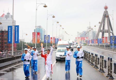 Torchbearer Ji Yonghai runs with torch during the 2008 Beijing Olympic Games torch relay in Xining, northwest China's Qinghai Province, on June 24, 2008. 