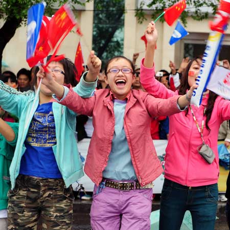 People cheer for the 2008 Beijing Olympic Games torch relay in Xining, northwest China's Qinghai Province, on June 24, 2008.