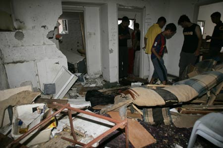 Palestinians observe the damage in a house after an Israeli military operation in the West Bank city of Nablus June 24, 2008.