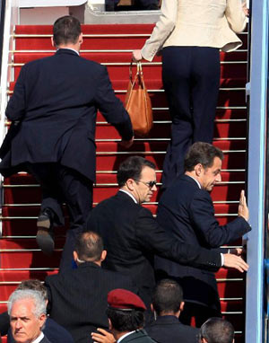 France's President Nicolas Sarkozy (center R) and his wife Carla Bruni-Sarkozy (top) are rushed by security officers into the presidential plane at Ben Gurion international airport near Tel Aviv June 24, 2008. 