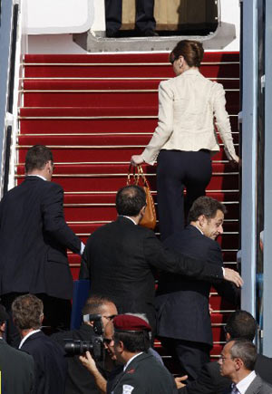 France's President Nicolas Sarkozy (center R) and his wife Carla Bruni-Sarkozy (top) are rushed by security officers into the presidential plane at Ben Gurion international airport near Tel Aviv June 24, 2008. 