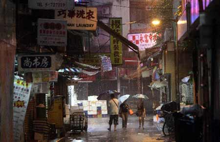 People holding umbrellas walk in rain in south China's Hong Kong on June 25, 2008. Hong Kong was affected by heavy rain as the Typhoon Fengshen headed towards the southern Chinese city. The Hong Kong Observatory issued the No. 8 Northeast Gale or Storm Signal on Tuesday and red warning on Wednesday.