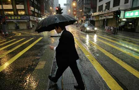 A man holding an umbrella walks in rain in south China's Hong Kong on June 25, 2008. Hong Kong was affected by heavy rain as the Typhoon Fengshen headed towards the southern Chinese city. The Hong Kong Observatory issued the No. 8 Northeast Gale or Storm Signal on Tuesday and red warning on Wednesday.
