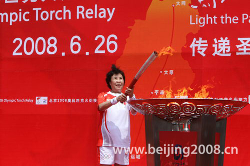 Last torchbearer Guo Fenglian, member of the Standing Committee of the National People's Congress (NPC), lights the cauldron, marking an end to the torch relay in Taiyuan, north China's Shanxi Province, June 26, 2008.