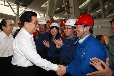 Chinese President Hu Jintao shakes hands with construction workers Wednesday in the Beijing South Railway Station, which is still final construction and will be put in formal use on August 1. [Photo: Xinhua]