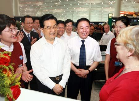 Chinese President Hu Jintao talks with foreign visitors in the main hall of the newly-built Terminal Three at the airport on June 25, 2008. [Photo: Xinhua]