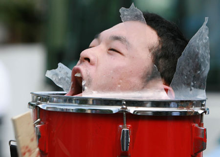 An anti-G8 protester puts his head in a broken drum during a rally in Kyoto, western Japan, on June 26, 2008, prior to the two-day G8 Foreign Ministers' Meeting to be held in this city from June 26 to 27. 