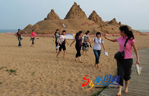 Visitors come to the 3rd International Sand Sculpture Festival, which kicked off in Haiyang, a coastal city in east China's Shandong province, on Thursday, June 26, 2008. [Photo: shm.com.cn]