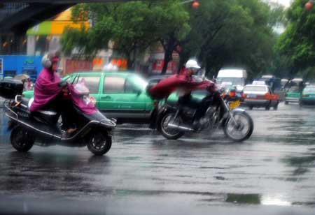 Vehicles run on a street in a shower of rain in Fuzhou, capital of southeast China's Fujian Province, June 25, 2008. Tropical storm Fengshen hit the southeast coast of China early on Wednesday, bringing heavy rain and strong winds.