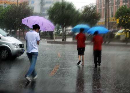 Pedestrians walk in a shower of rain in Fuzhou, capital of southeast China's Fujian Province, June 25, 2008. Tropical storm Fengshen hit the southeast coast of China early on Wednesday, bringing heavy rain and strong winds.