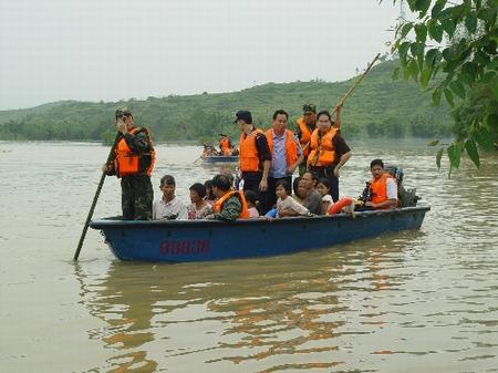 The picture taken on June 27 shows that soldiers help evacuate people hit by the Torrential rain in the Heyuan City of Guangdong Province evacuate.