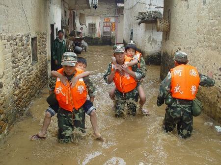 The picture taken on June 27 shows that soldiers help evacuate people hit by torrential rain in Heyuan City, Guangdong Province.