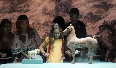 People view exhibits at the 'Story of the Horse' exhibition in Hong Kong, south China, on June 27, 2008. About 40 exhibits were displayed in the six-month exhibition for the celebration of Hong Kong's co-hosting of the Equestrian Events of the Beijing 2008 Olympic Games, to be held in August.[Photo: Xinhua]