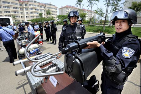 A policeman introduces the function of a kind of new equipment to be used during the Beijing Olympic Games, in Qingdao, a co-host of the Games in east China's Shandong Province, on June 27, 2008. An anti-terror drill was held Friday here, as the city will hold sailing competition of the 2008 Olympic Games from August 8 to 24. 