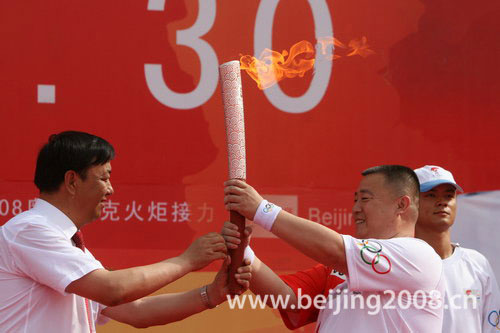 The first torchbearer Huo Qinghua of the Wuzhong leg starts the Olympic torch relay on Monday morning, June 30, 2008. [Photo: beijing2008.cn]