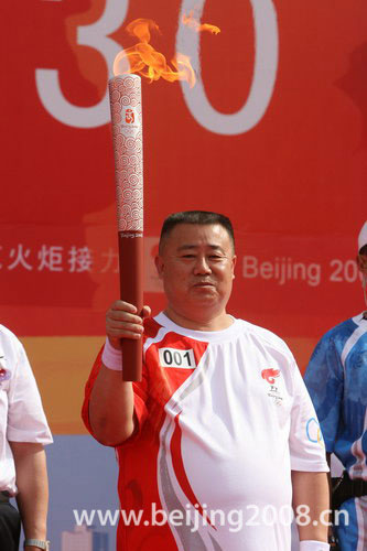 The first torchbearer Huo Qinghua of the Wuzhong leg starts the Olympic torch relay on Monday morning, June 30, 2008. [Photo: beijing2008.cn]