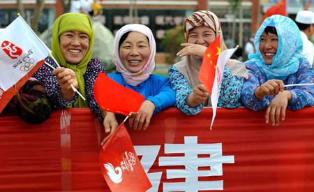 Local residents cheer for the 2008 Beijing Olympic Games torch relay in Wuzhong City of northwest China's Ningxia Hui Autonomous Region during the Olympic torch relay June 30, 2008. 