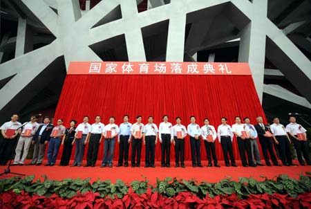 Officials have photos taken on the ceremony launching China's National Stadium, known as the Bird's Nest, on June 28, 2008. Covering 20.4 hectares in the Beijing Olympic Green, the bowl-shaped and girder-structured huge nest with 91,000 seats will hold the opening and closing ceremonies, track and field events, men's soccer of the coming 2008 Beijing Olympic Games, and some events for the later Paralympics. 