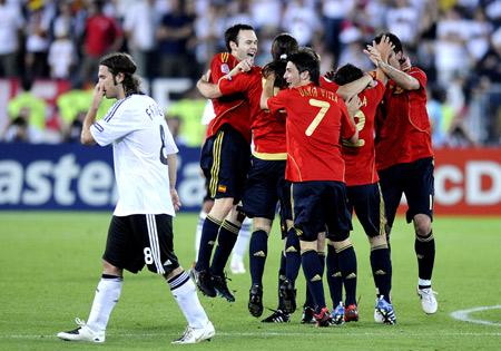 Spain's players celebrate victory as Germany's midfielder Torsten Frings (L) walks by after the Euro 2008 championships final between Germany and Spain in Vienna, Austria, on June 29, 2008. 