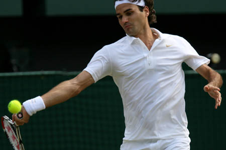 Switzerland's Roger Federer returns the ball to Australia's Lleyton Hewitt during the fourth round match of the men's singles at the Wimbledon Tennis Championships in London, capital of England, on June 30, 2008. Federer won 3-0 and advanced into the quarterfinal.