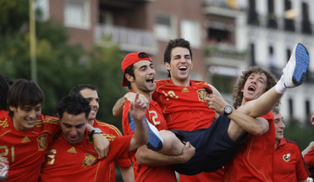 Spain's player Cesc Fabregas (2nd R) is held up by team mates Raul Albiol and Carles Puyol (R) as they celebrate their victory in the Euro 2008 soccer championship after arriving at Madrid's Colon square, June 30, 2008.(Xinhua/Reuters Photo)