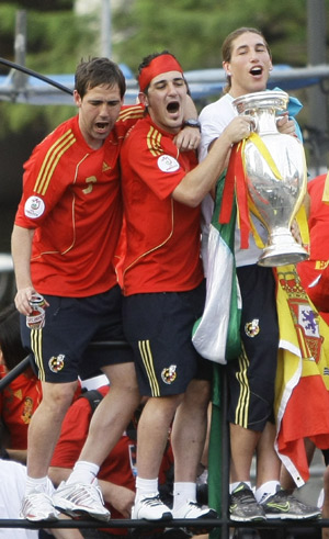 Spain's Fernando Navarro (L), David Villa and Sergio Ramos (R) celebrate with the Euro 2008 trophy as the national soccer team arrive at Madrid's Colon square June 30, 2008.(Xinhua/Reuters Photo)