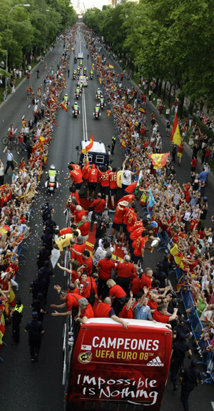 Spain's soccer players celebrate winning the Euro 2008 soccer championship on the top of a bus surrounded by cheering crowds as they arrive at Madrid's Colon square June 30, 2008.(Xinhua/Reuters Photo)