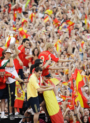 Members of Spain's national soccer team wave to the crowd from the top of a bus as they celebrate their Euro 2008 soccer tournament victory at Madrid's Colon square June 30, 2008.(Xinhua/Reuters Photo)