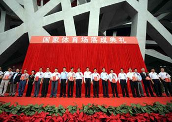 Working staff and guests pose for photos in front of China's National Stadium, known as the Bird's Nest, in Beijing, capital of China, June 28, 2008. It was announced early Saturday that China's National Stadium is fully operational, singaling the readiness of all 37 venues for the upcoming Beijing Olympics in August. (Xinhua/Luo Xiaoguang)