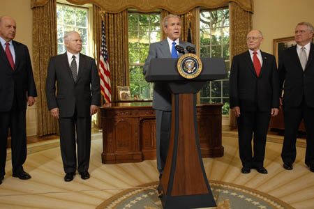 U.S. President George W. Bush (C) stands with Deputy Secretary of State John Negroponte (L), Defense Secretary Robert Gates (2nd L), Veterans Affairs Secretary James Peake (2nd R) and Director of White House Office of National Drug Control Policy John Walters (R) as he makes a statement in the Oval Office after signing an Iraq war supplemental bill at the White House in Washington, June 30, 2008.