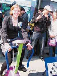 American Anna Zimmermann powers compact fluorescent light bulbs by pedaling a bicycle during an event held by Global Village of Beijing on Earth Day.