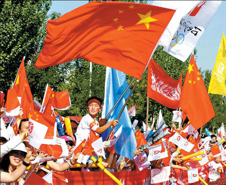 Flag-waving spectators cheer on the torch relay yesterday, in Yinchuan, Ningxia. (Photo: Xinhua)