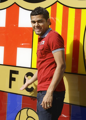 Former Sevilla's soccer player Daniel Alves of Brazil smiles in front of the Barcelona office before his official presentation at Nou Camp stadium in Barcelona July 1, 2008. Sevilla said goodbye to Brazil full back Alves on Tuesday ahead of the 25-year-old completing his transfer to Primera Liga rivals Barcelona.(Xinhua/Reuters Photo)