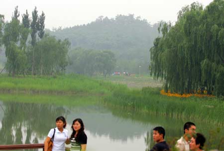 People visit the Beijing Olympics Forest Park in Beijing, capital of China, July 1, 2008. The 680-hectare park, which is the largest city park in Beijing, was firstly opened to public Tuesday. It will temporarily shut down on July 5 and reopen on August 9.