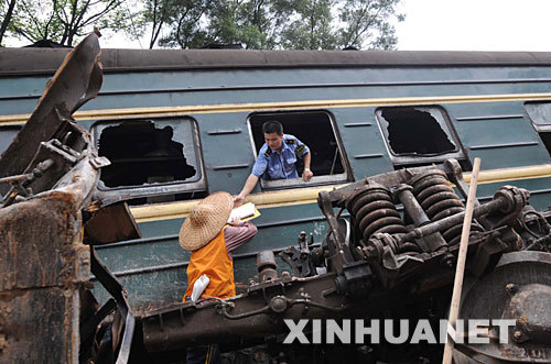 The conductor of a derailed train helps retrieve passengers' belongings after a crash in south China's Guangxi Zhuang Autonomous Region on Monday, June 30, 2008. [Photo: Xinhuanet]