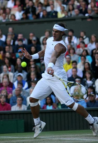 图Rafael Nadal returns a ball to Andy Murray in the quarterfinals of men's singles at the Wimbledon Tennis Championships in London, capital of England. 