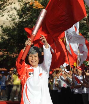 Torchbearer Fan Jinshi, president of the Institute of Dunhuang displays the torch during the 2008 Beijing Olympic Games torch relay in Dunhuang, a city of northwest China&apos;s Gansu Province, on July 5, 2008.