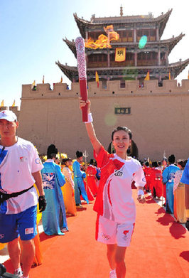 The 207th torchbearer Zuo Xia carries the torch during the Torch Relay in Jiayugan city, Gansu province, on July 6.