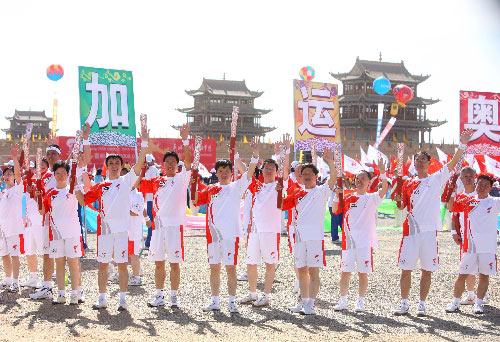 Torchbearers wave at the crowds during the Torch Relay in Jiayugan city, Gansu province, on July 6. 
