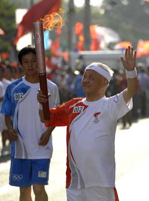 Torchbearer Tang Zhongli runs with the torch during the 2008 Beijing Olympic Games torch relay in Lanzhou, capital of northwest China's Gansu Province, on July 7, 2008. 