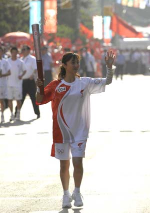 Torchbearer Ding Huiru runs with the torch during the 2008 Beijing Olympic Games torch relay in Lanzhou, capital of northwest China's Gansu Province, on July 7, 2008. 