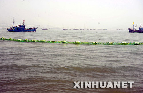 Fishing boats clear the algae from water in a sailing event venue where athletes are preparing for the competition of the Olympic Games in Qingdao city in east China's Shandong Province on Sunday, July 6, 2008. [Photo: Xinhua]