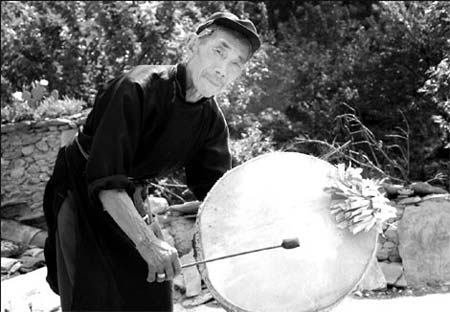Shibi Wang Zhisheng beats goat skin drum at a burial ritual held for people died in the May 12 earthquake.