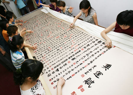 The craftswomen needle to finish the embroidery work named The Olympic Fu (Fu, descriptive prose interspersed with verse) in Suzhou, east China's Jiangsu Province, July 6, 2008. Eleven local craftswomen make the 3.5-meter-long embroidery that consisted of 908 Chinese characters wrote by 101 Chinese generals, which tells the general history of the Olympic games and depicts the longing of Chinese people for the Olympic games. (Xinhua/Xu Zhiqiang)