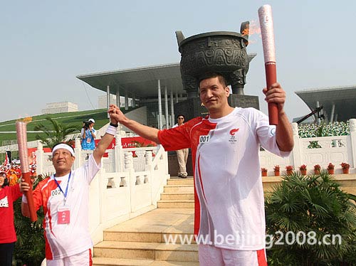 Bateer relayed the Olympic flame to another torchbearer in Hohhot, Inner Mongolia on July 8.