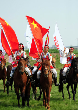 People ride horses to welcome the Olympic torch during the 2008 Beijing Olympic Games torch relay in Hohhot, capital of north China's Inner Mongolia Autonomous Region, on July 8, 2008.
