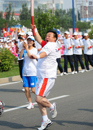 Wu Liping runs with the torch during the 2008 Beijing Olympic Games torch relay in Hohhot, capital of north China's Inner Mongolia Autonomous Region, on July 8, 2008.