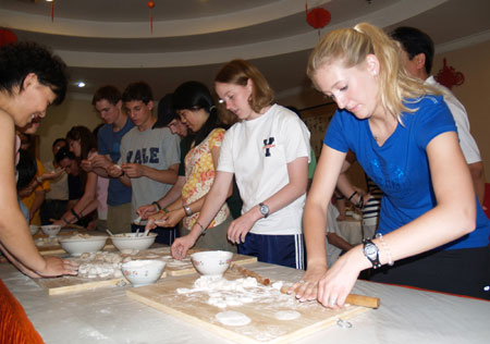 A 12 members USA President Awardee Students Delegation get experience of wrapping up Chinese dumplings, in Ruyang, central China's Henan Province, July 8, 2008. 